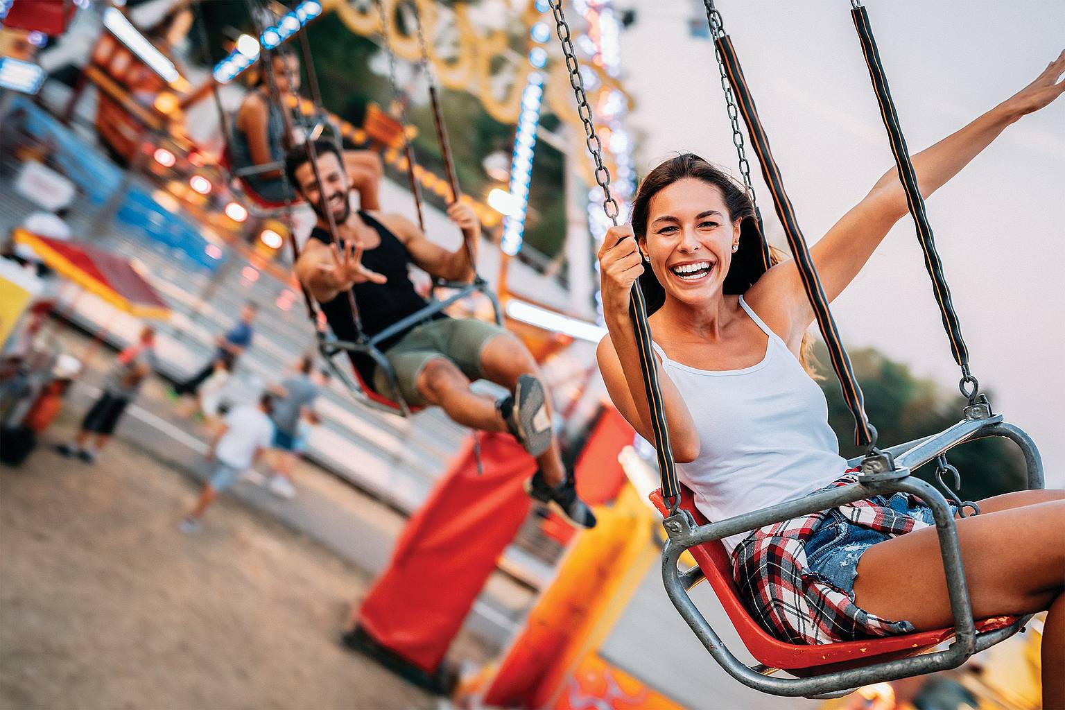 Happy woman riding a carnival swing.
