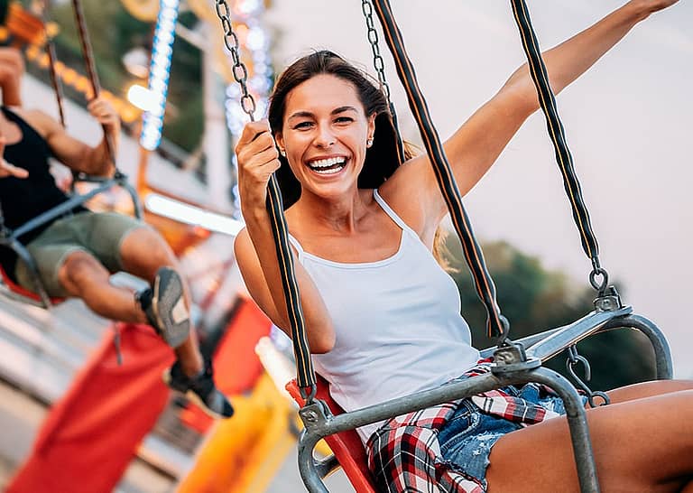 Happy woman riding a carnival swing.